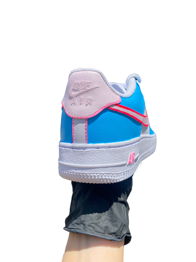 Custom sneakers with a blue base, white swoosh, and pink accents