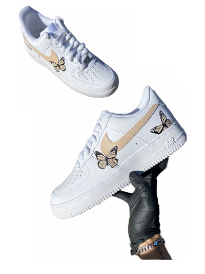 White sneakers with hand-painted butterflies in beige and peach tones. Checkmark painted beige