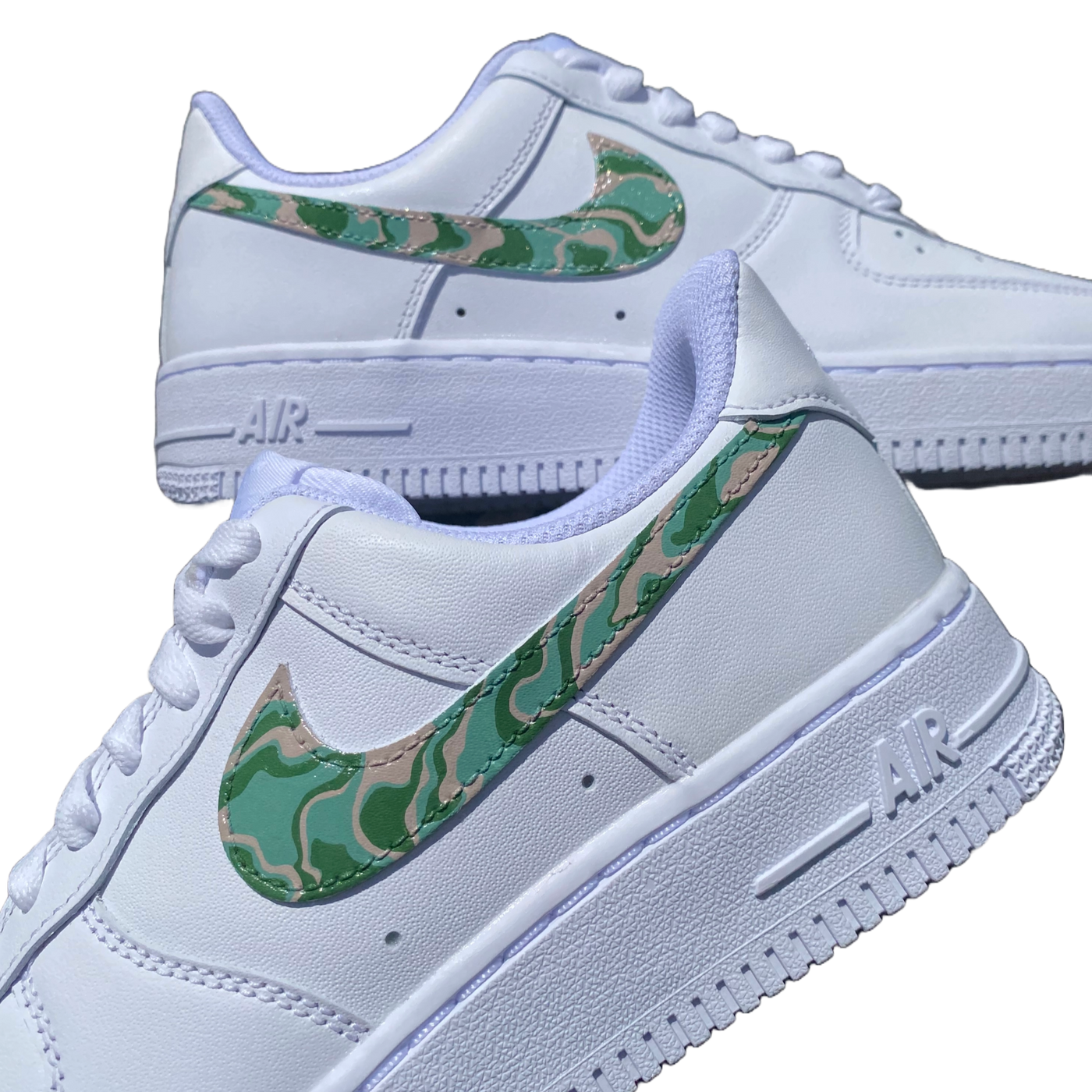 Close up of hand-painted spiral design on what would otherwise be a white pair of Air Force 1's. Colors include moss green, forest green and biege.