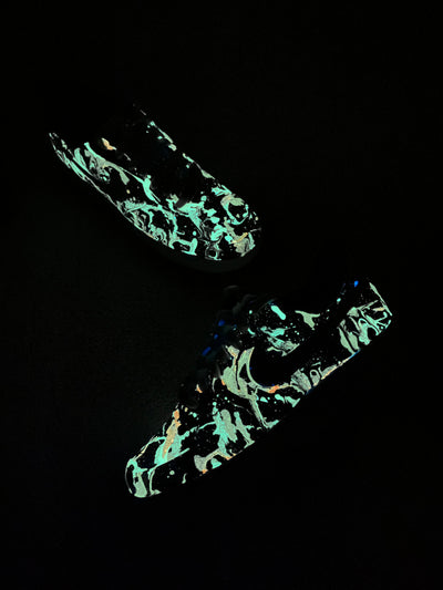 Glow-in-the-dark sneakers with a colorful abstract splatter paint design