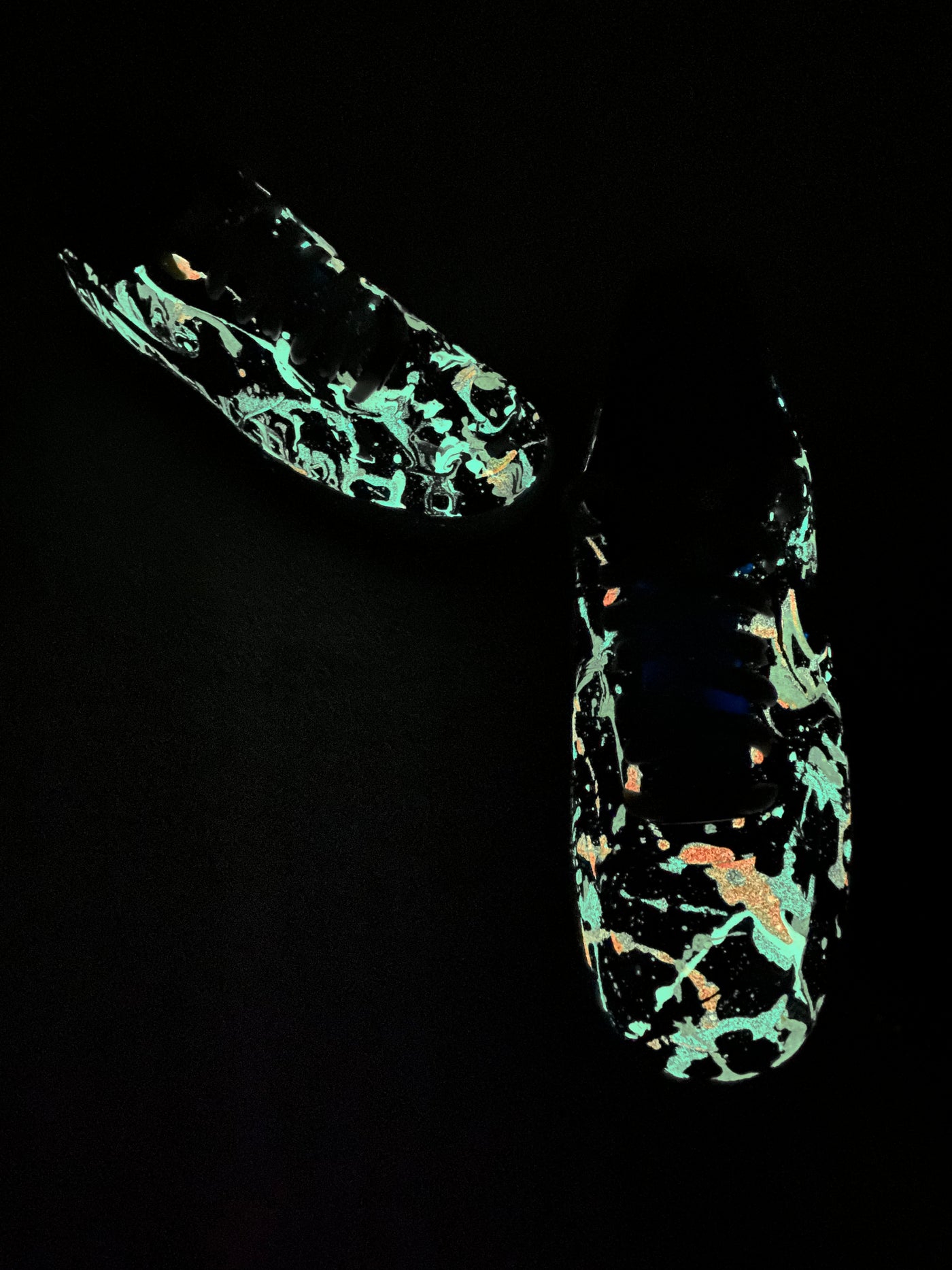 Glow-in-the-dark sneakers with a colorful abstract splatter paint design