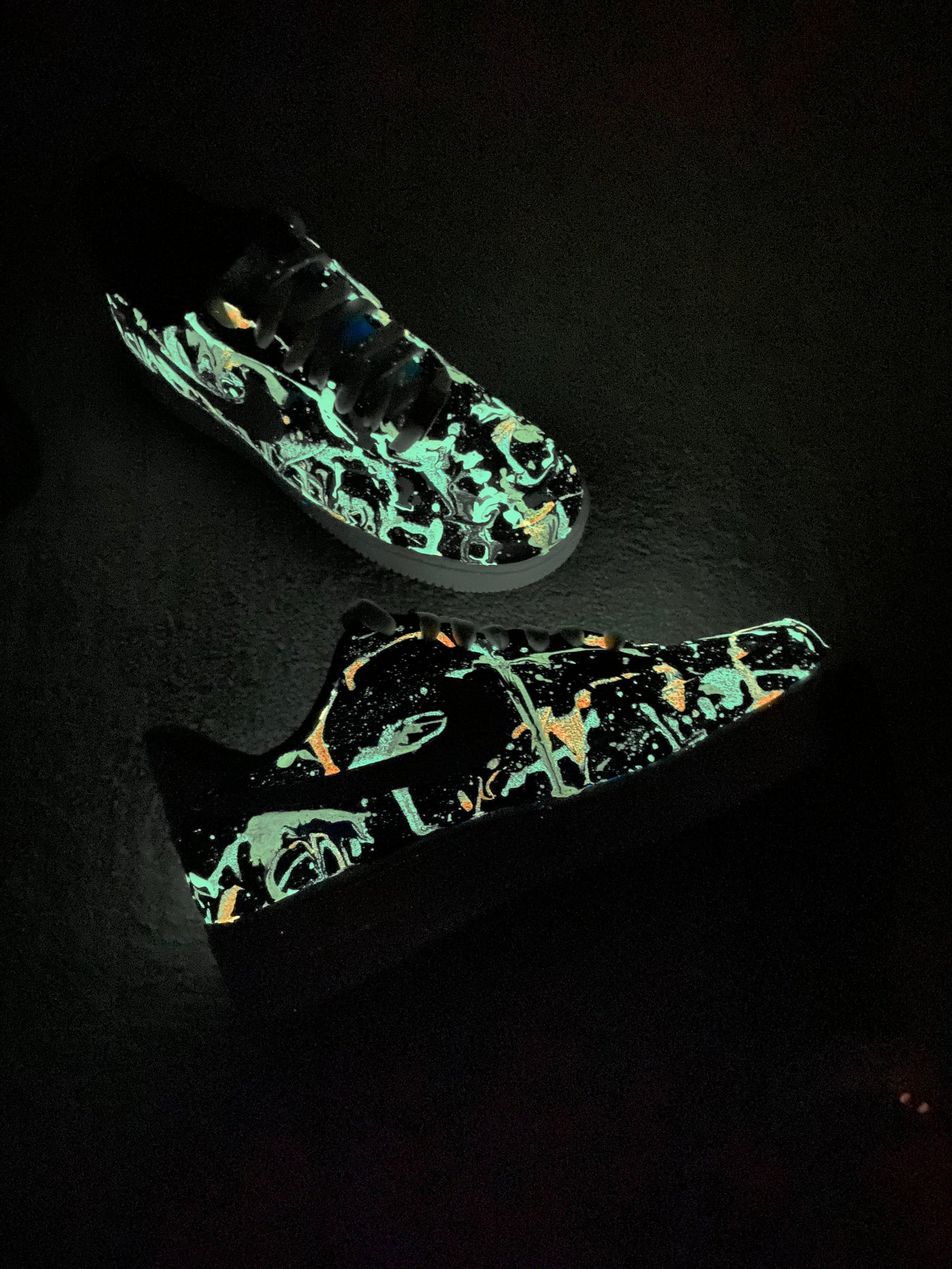 Glow-in-the-dark sneakers with a colorful abstract splatter paint design